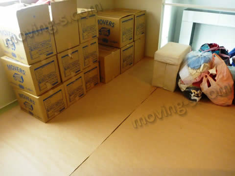 引越し荷物を運び入れる前に、畳の部屋をダンボール素材のシートで養生