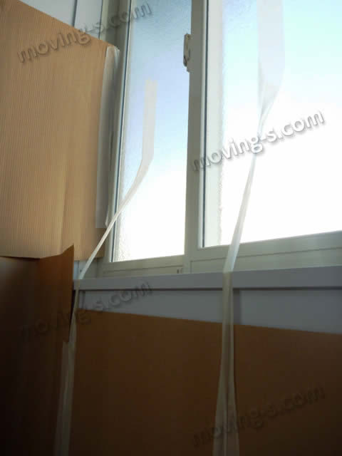 壁に養生テープが触れないよう、窓枠と窓ガラスを利用して養生資材を吊り下げるようにうまく養生した様子