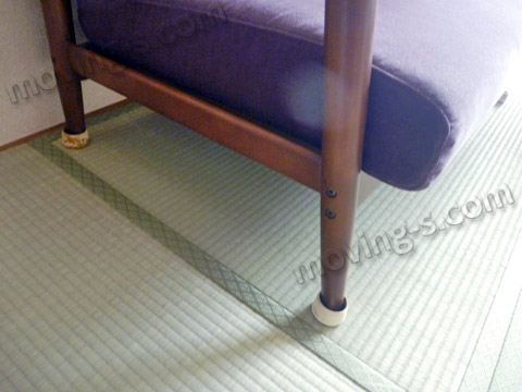 引越し先の和室に置かれたソファーの脚（キャップが付いています）